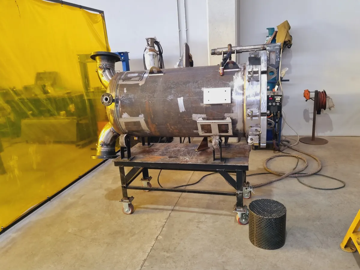 Stainless steel pressure vessel under fabrication with nozzles and flanges