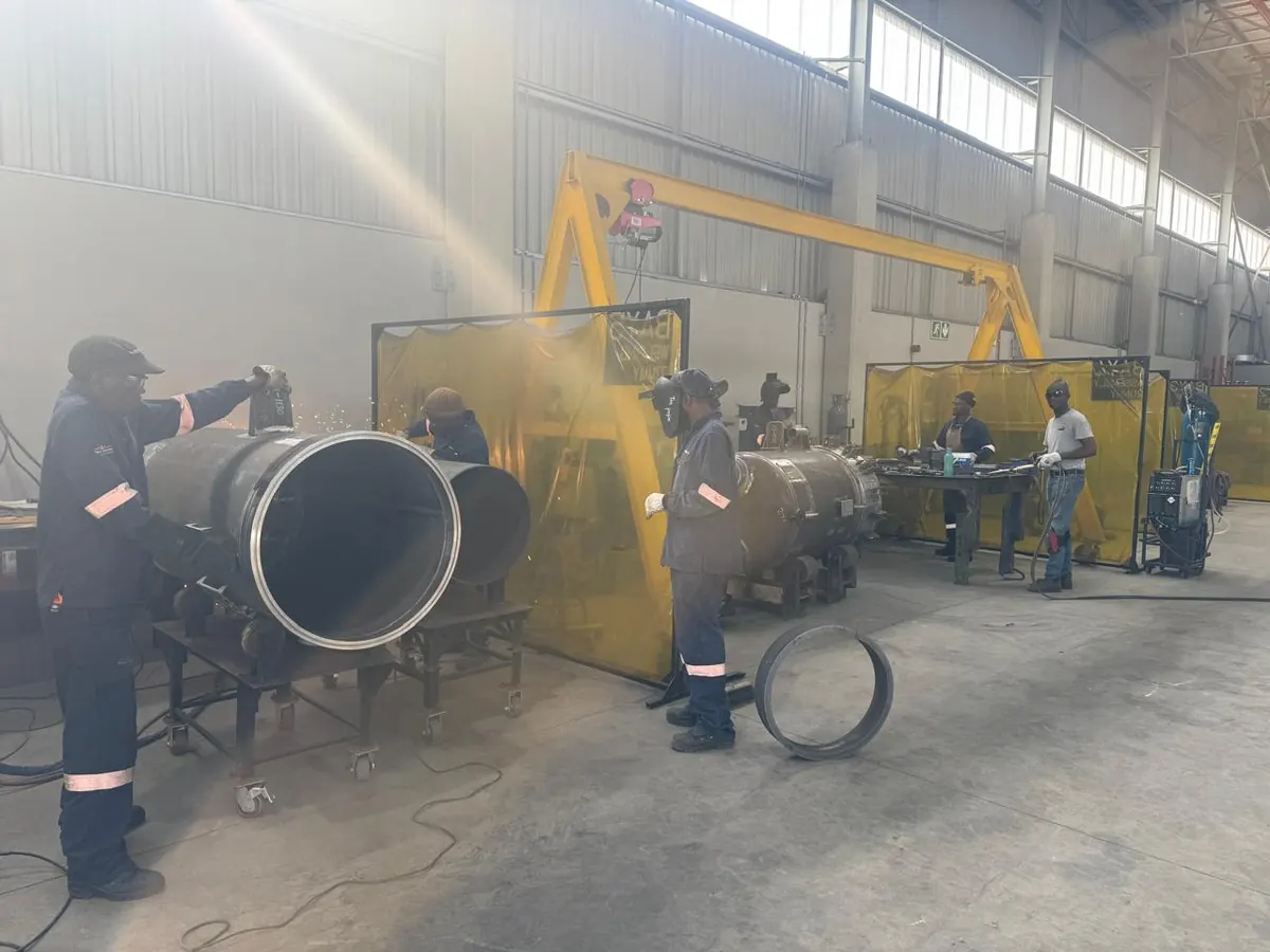 GX2 welders and fitters assembling pressure vessel shells in the workshop